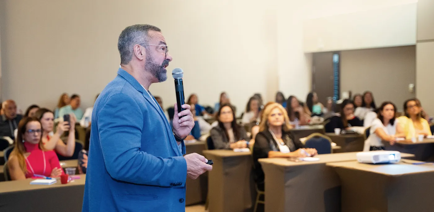 Médico palestrando para uma plateia de profissionais durante uma imersão da Academia da Menopausa